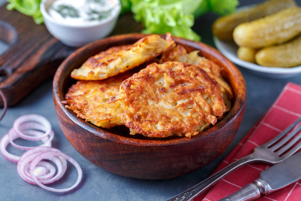 Potato pancakes dish in bowl with sour cream and vegetables - Fotografie, Obrázek