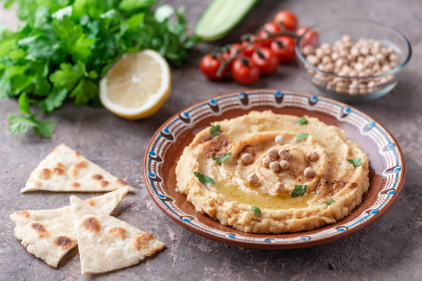 Traditional hummus dish in plate on table with vegetables - Foto, Imagem