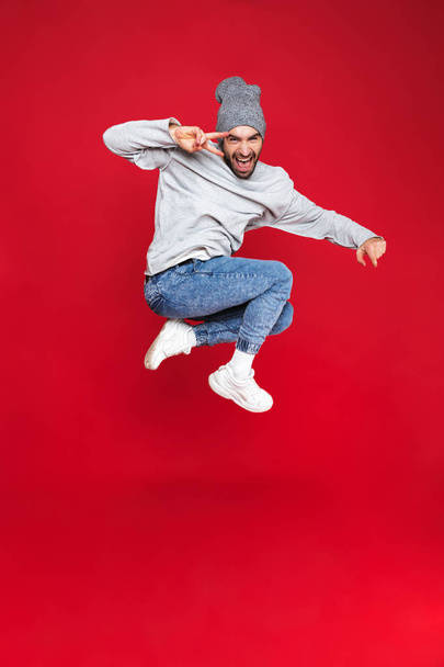 Full length photo of beautiful man smiling and jumping isolated  - Foto, Bild