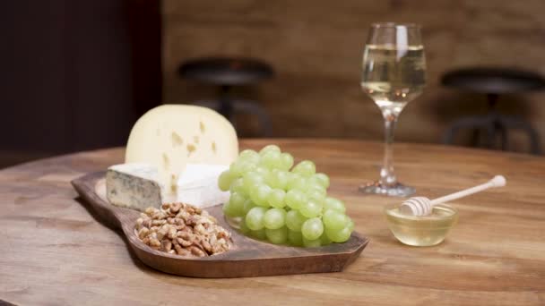 Sajt és egy fából készült asztal, méz, dió, bor és a szőlő - Felvétel, videó