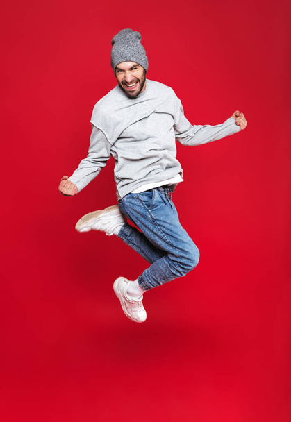 Full length photo of optimistic man smiling and jumping isolated - Fotó, kép