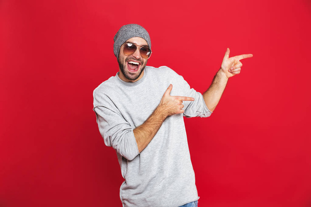 Image of cheerful man 30s in sunglasses laughing and pointing fi - Valokuva, kuva