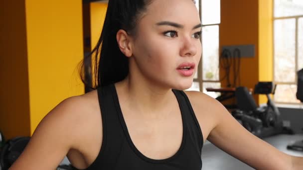 Młoda dziewczyna Azji, uprawiania sportu na eliptyczny trener siłowni. - Materiał filmowy, wideo