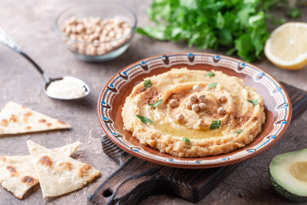 Traditional hummus dish in plate on wooden board on table - Foto, Imagen