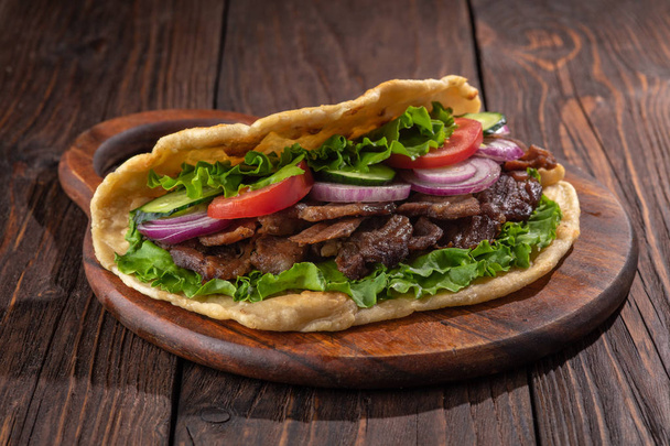 Fresh tortilla sandwich with beef and vegetables on rustic table - Photo, Image