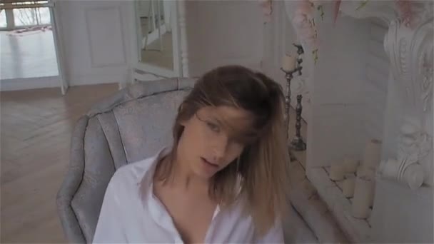 Beautiful young woman at the window in a white shirt. dancing and relaxing - Imágenes, Vídeo