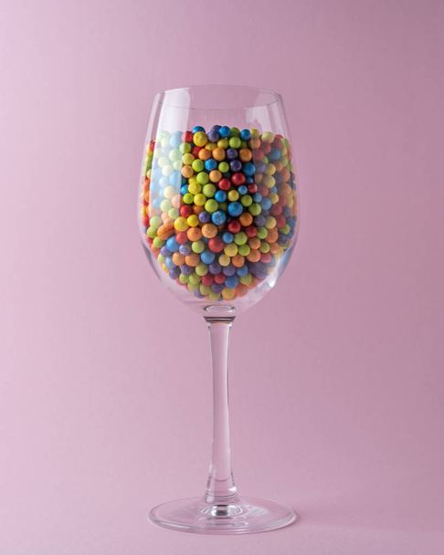 Celebration background with wine glass and colorful confetti. Minimal party concept. - Foto, Imagen