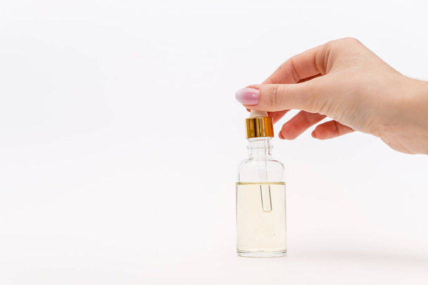 Dropper glass Bottle Mock-Up. Oily drop falls from cosmetic pipette on white background - Foto, Bild