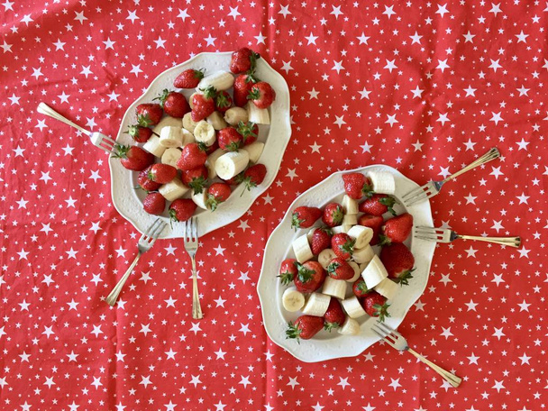 fraises et bananes dans une assiette. nappe festive rouge
 - Photo, image