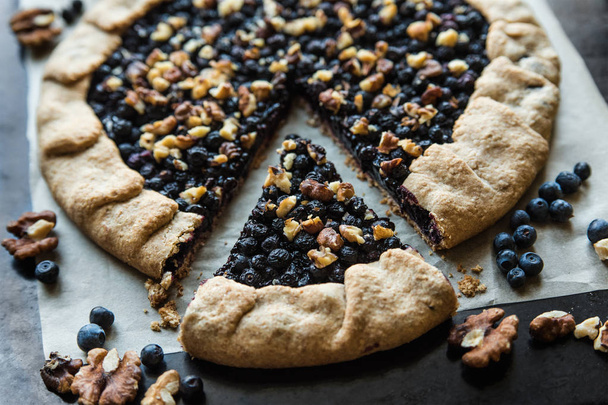 Homemade blueberry galette on a paper on a dark background, top view - Photo, Image