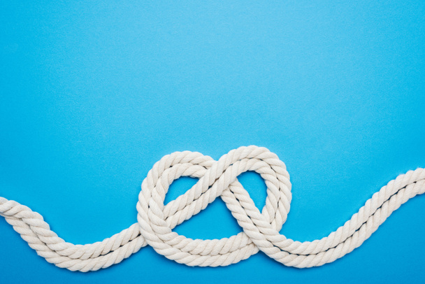 white ropes with sailor knot isolated on blue - Foto, Bild