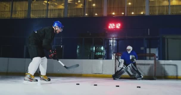 Professional jääkiekkoilija ja maalivahti juna lävistys kiekko maalia kohti. Maalivahti ja pelaaja koulutuksessa. Hidastus
 - Materiaali, video