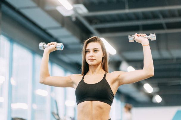 Beautiful girl in the gym. Sports and fitness, healthy lifestyle. - 写真・画像
