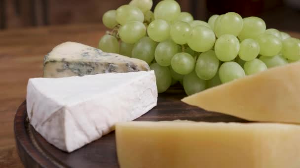 Dorblu, Gouda és brie sajtot szolgálnak fel, a fehér szőlő - Felvétel, videó