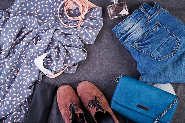 Жіночий одяг, аксесуари, взуття (блакитна блузка, джинси, теракотове взуття, сумка). Модний одяг. Концепція покупок. Вид зверху. Модні, насичені кольори
 - Фото, зображення