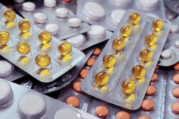 Žluté, bílé a oranžové lékařské tablety v balení, tablety a kapsle a tablety balené v blistru - Fotografie, Obrázek