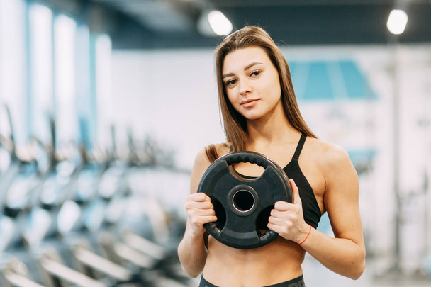 Beautiful girl in the gym. Sports and fitness, healthy lifestyle. - Фото, зображення