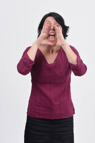 woman putting a hand in mouth and is screaming on white backgrou - Φωτογραφία, εικόνα