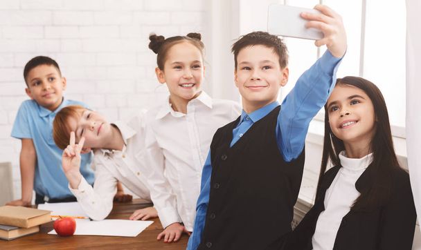 Bambini felici che si fanno selfie in classe
 - Foto, immagini