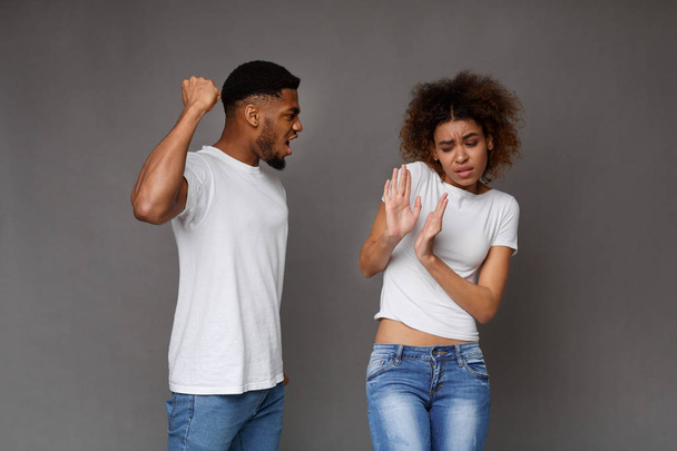 Afrikanisch-amerikanischer Mann schlägt Ehefrau, häusliche Gewalt - Foto, Bild