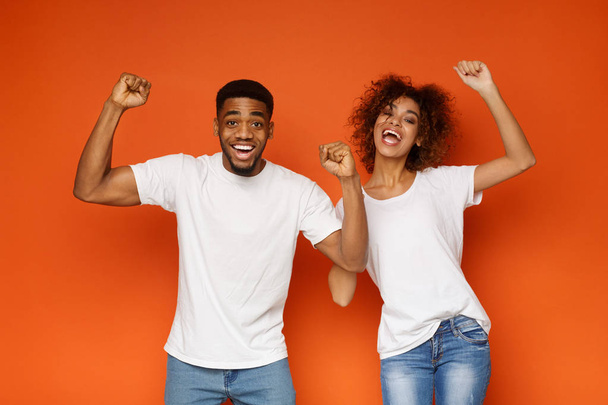 Feliz emocional negro hombre y mujer disfrutando de éxito juntos
 - Foto, imagen