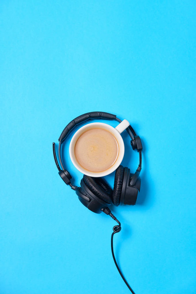 Music or podcast background with headphones and cup of coffee on - 写真・画像