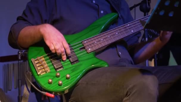 Músico tocando el bajo verde en concierto
 - Imágenes, Vídeo