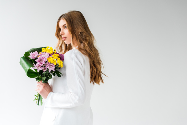 ragazza sognante tenendo bouquet di fiori selvatici su bianco
  - Foto, immagini
