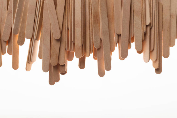 Many wooden ice cream sticks in chaotically row on white backgro - Foto, Bild