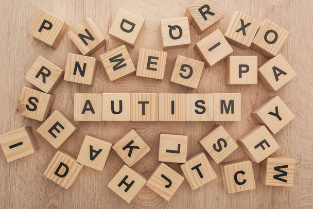 top view of autism lettering made of wooden blocks among another letters - Foto, afbeelding