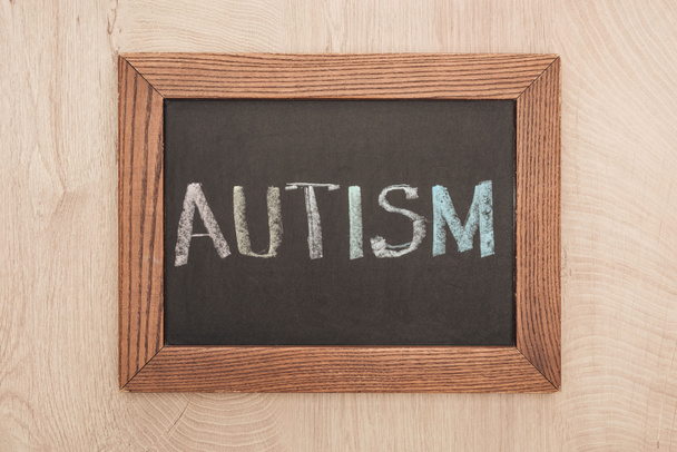 top view of chalkboard with autism lettering on wooden table - Foto, immagini