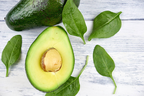 Slices of avocado on white background. Whole and half with leaves. - Foto, Imagem