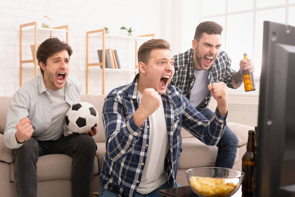 Doel. Erg enthousiast vrienden kijken naar voetbalwedstrijd - Foto, afbeelding