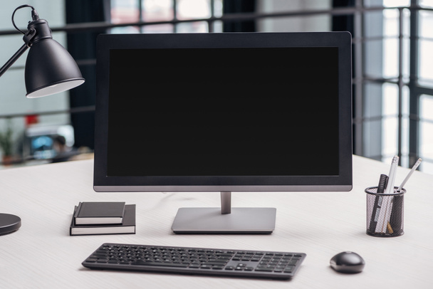 монитор компьютера с чистым экраном и канцелярскими принадлежностями на рабочем месте в современном офисе
 - Фото, изображение