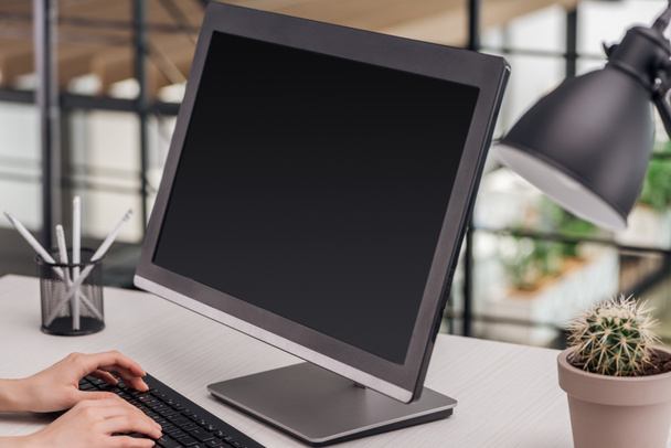 vista ritagliata di donna digitando sulla tastiera del computer sul posto di lavoro
 - Foto, immagini