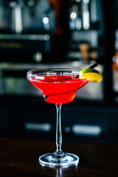 Cosmopolitan cocktail with lime on bar counter in a nightclub - Фото, зображення