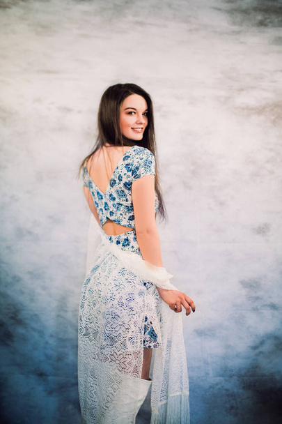 mujer joven y hermosa posando en vestido azul y botas altas blancas
 - Foto, Imagen