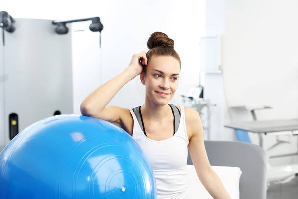 Fitness trainer with a blue gym ball after training. - Photo, image