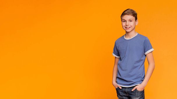 Adorable écolier posant sur fond orange
 - Photo, image