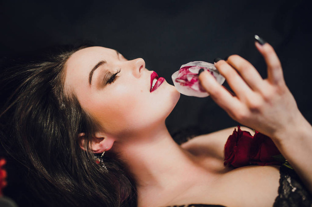 young woman in black lingerie posing with red rose frozen in ice - Foto, immagini