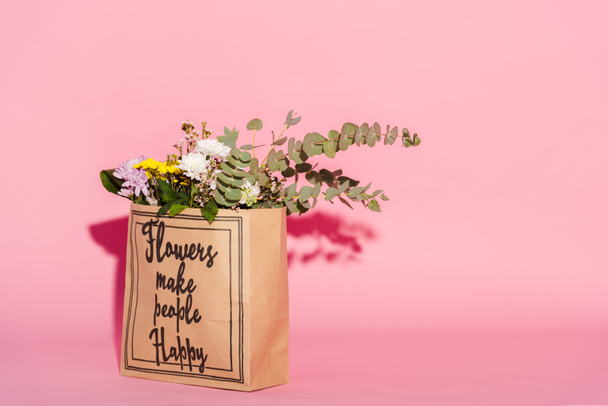 flores y hojas de eucalipto en bolsa de papel con flores hacen feliz a la gente letras en rosa
 - Foto, Imagen