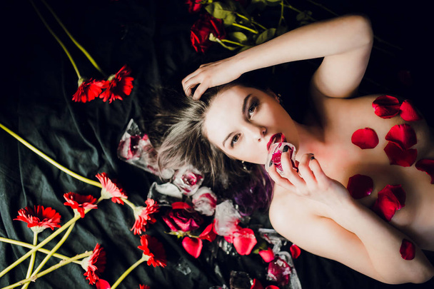young topless woman posing on black lining with flowers - Fotó, kép
