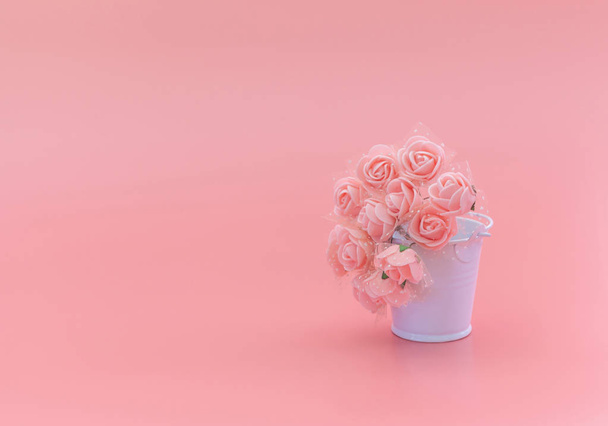 White bucket with flowers on a pink background, the concept of the holiday, Mother's Day, March 8. - Fotó, kép