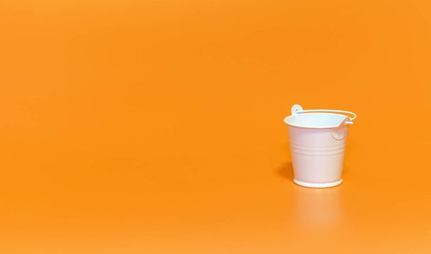 White bucket on orange background, minimalism concept - Fotó, kép