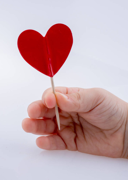 Λίγο κόκκινο χρώμα σχήμα καρδιάς στο χέρι - Φωτογραφία, εικόνα