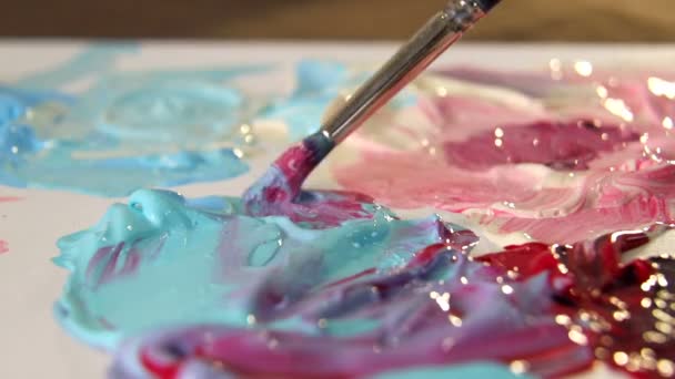 Artista mezcla diferentes colores de pintura acrílica con un pincel para dibujar. Preparación de colores para el dibujo de cuadros
 - Metraje, vídeo