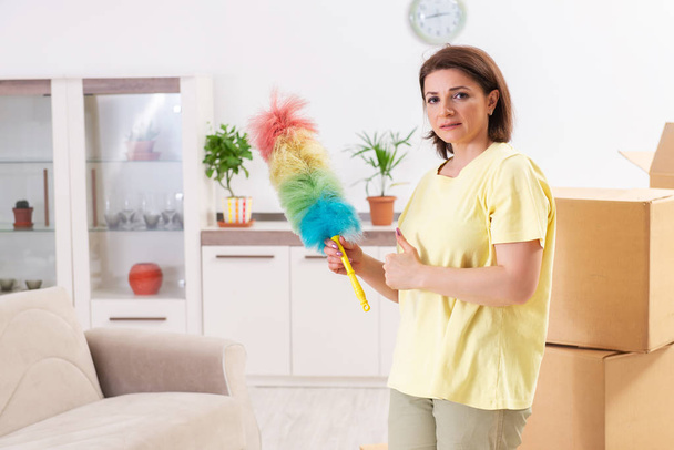 Kobieta w średnim wieku czyszczenia nowe mieszkanie - Zdjęcie, obraz