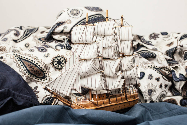 Concepts of business and creativity. model of a sailing ship in a blue bedding. Close up - 写真・画像