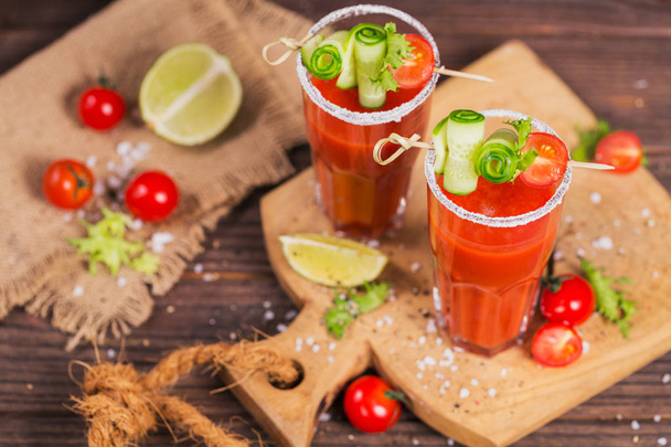Two glasses of tomato juice decorated with fresh tomatoes, cucum - Photo, image