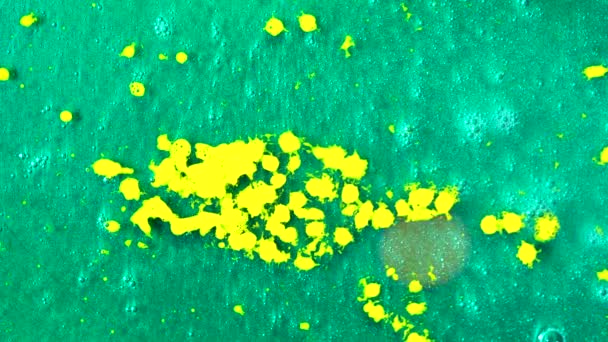 Bovenaanzicht van gele verf druppels vallen aan de prachtige turquoise oppervlakte, kunst concept. Vloeibare gele inkt druipen beneden naar teal oppervlakte. - Video